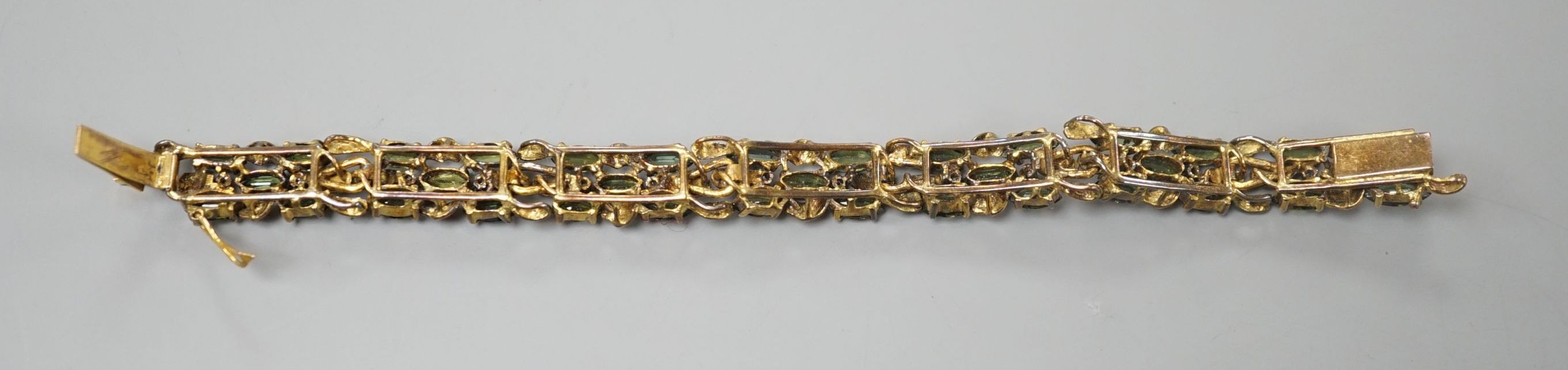 A modern yellow metal, multi green stone and multi diamond chip set bracelet, 16.5cm, gross weight 23.8 grams.